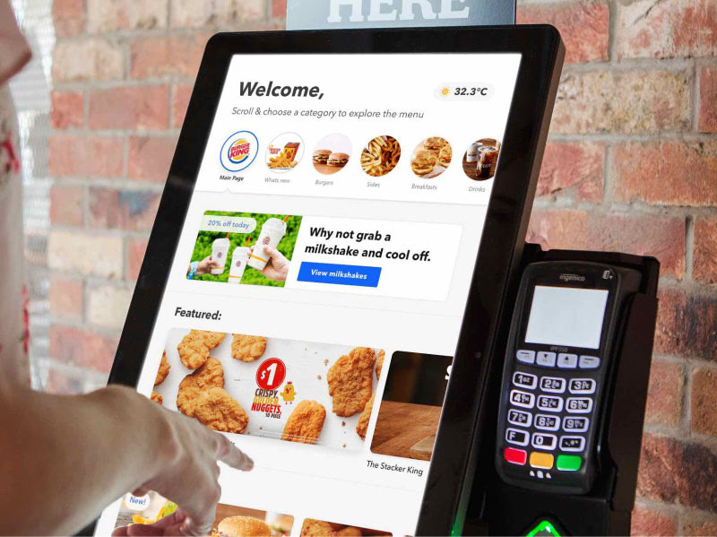 A person ordering food on a digital screen